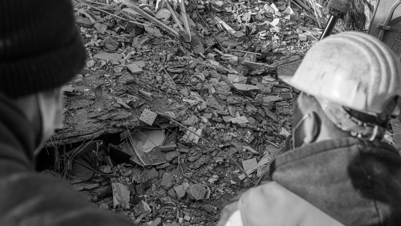 black and white construction site with people looking on