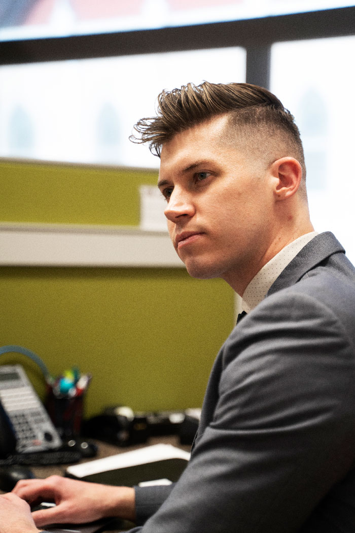 man in front of a computer, turned and looking toward the left