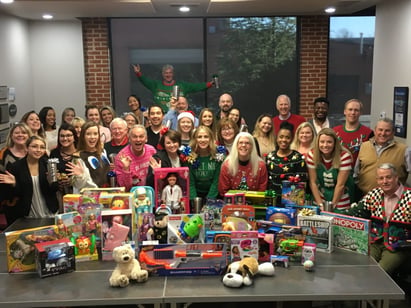 team gathered around a table of toys for Christmas drive
